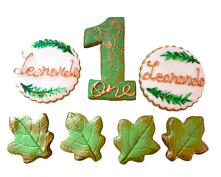Biscotti decorati a forma di foglie d’autunno e numero 1, realizzati artigianalmente in pasta frolla e pasta di zucchero, ideali per compleanni e feste a tema autunnale.