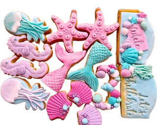 Set di biscotti decorati a mano a tema Sirenetta con conchiglie, stelle marine, cavallucci marini, code di sirena e meduse in pasta di zucchero, ideali per feste e compleanni a tema mare.