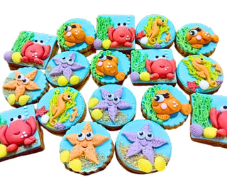 Set di 17 biscotti decorati a mano a tema tesori del mare con stelle marine, granchi, cavallucci marini e pesciolini colorati in pasta di zucchero