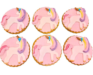 Biscotti decorati a tema unicorno rosa in pasta frolla con pasta di zucchero, ideali per compleanni e feste bambini.